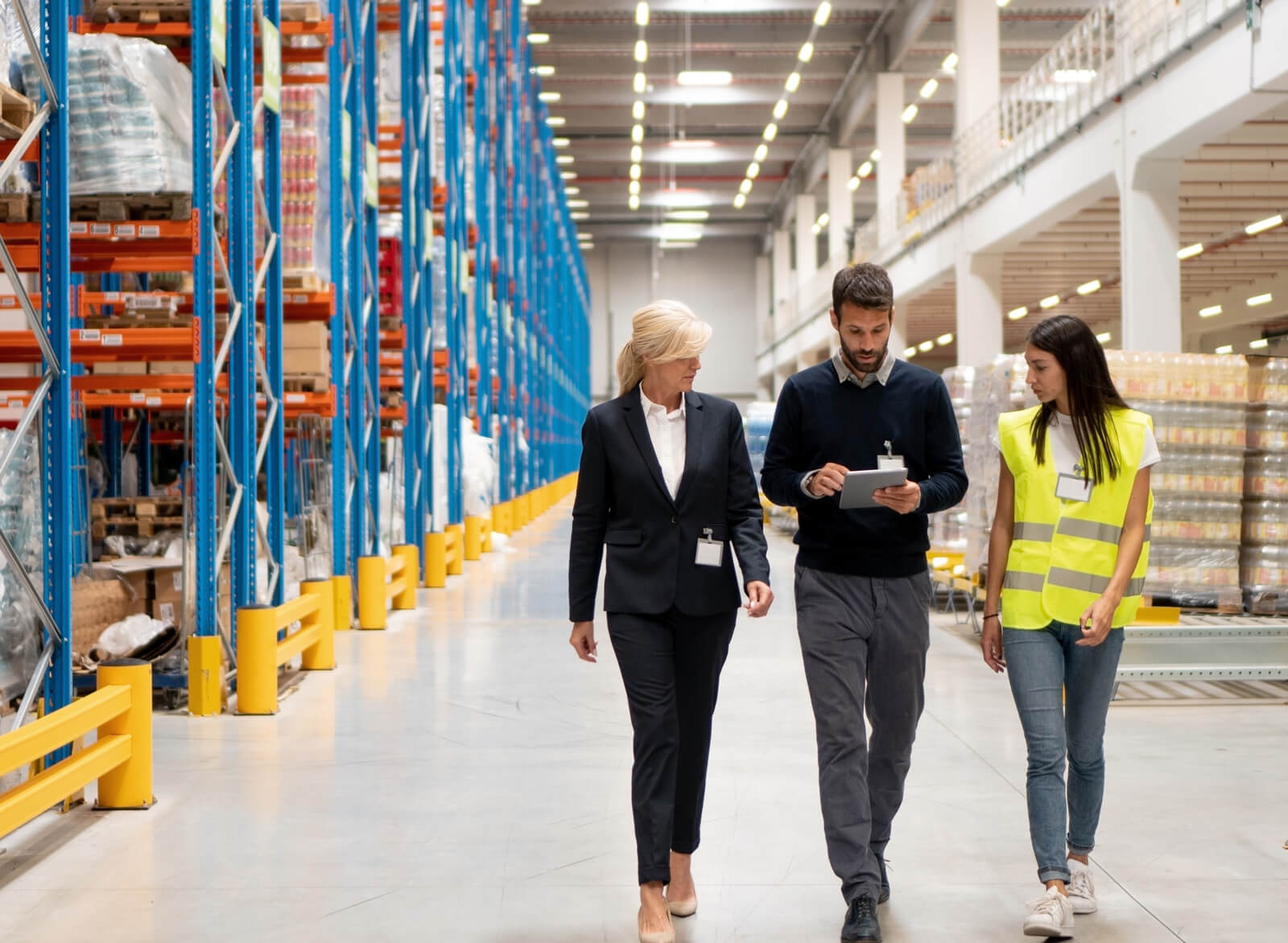 Gruppe von Menschen, die durch ein Lager gehen und sich auf ihre Arbeit konzentrieren.